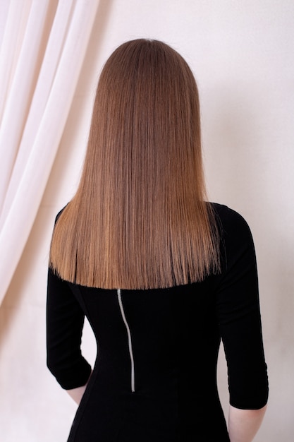 Photo dos femelle avec de longs cheveux bruns sains et droits dans un salon de coiffure