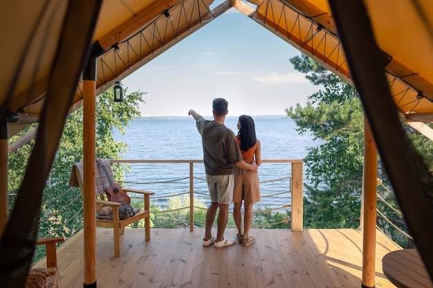 Dos de jeune homme et femme debout devant le bord de mer