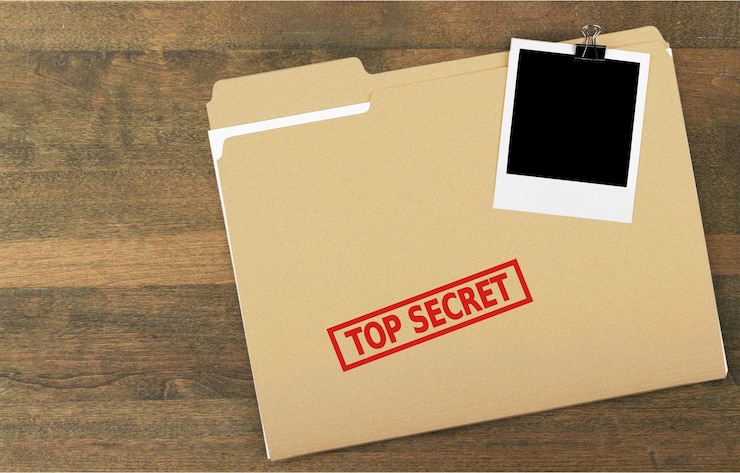 Photo un dossier avec les mots "top secret" estampillé dessus, isolé sur un fond blanc.