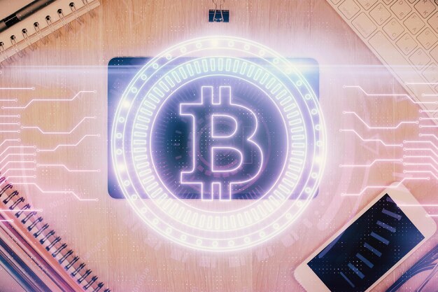 Double exposition de l'hologramme du thème blockchain sur la table avec le téléphone Vue supérieure Concept de technologie crypto