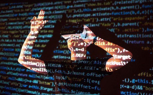 Double exposition d'un homme caucasien et un casque de réalité virtuelle est vraisemblablement un joueur ou un hacker cracking le code dans un réseau sécurisé ou serveur avec des lignes de code