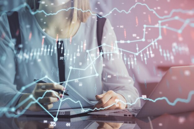 Double exposition des mains de femme d'affaires tapant sur ordinateur et dessin d'hologramme graphique financier Concept d'analyse boursière