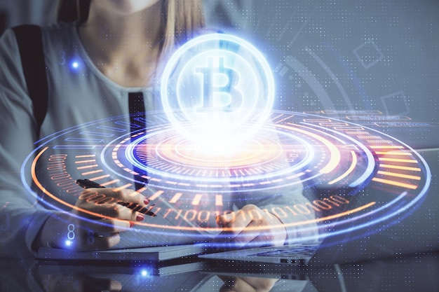 Double exposition des mains de femme tapant sur l'ordinateur et l'hologramme du thème du marché de la crypto dessinant le concept Blockchain