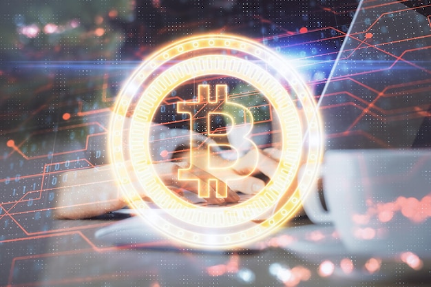 Double exposition de mains de femme tapant sur un ordinateur et un hologramme sur le thème du marché de la cryptographie, dessinant le concept Blockchain