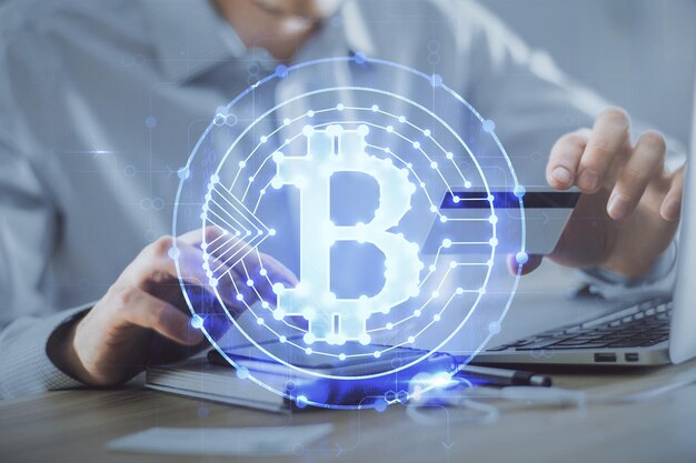 Double exposition des mains de l'homme tenant une carte de crédit et un dessin de thème d'entreprise crypto Blockchain numérique et concept de commerce électronique