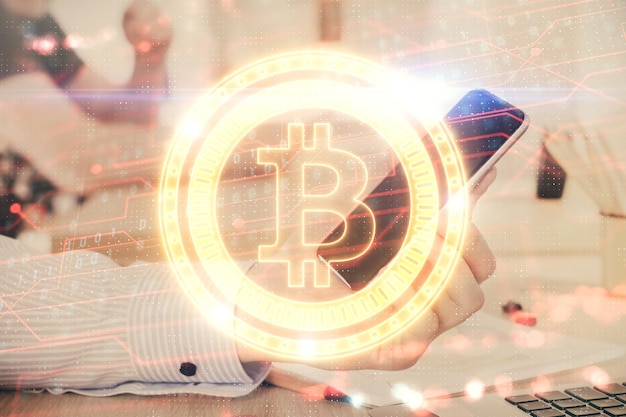 Double exposition des mains de l'homme tenant et utilisant un téléphone et une crypto-monnaie dessin sur le thème de la blockchain