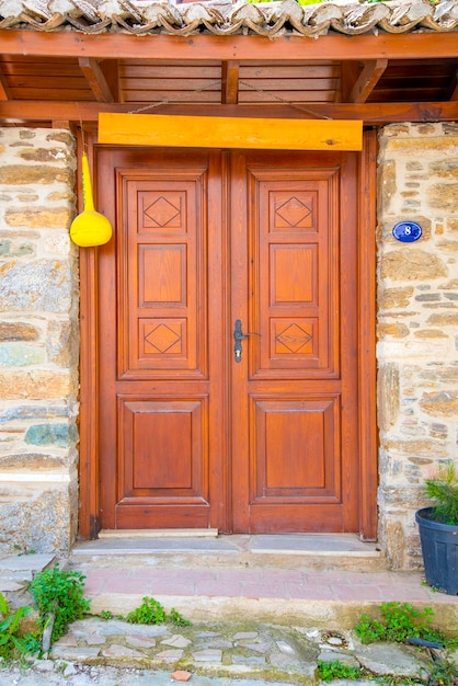 Photo une double porte en bois avec des fenêtres marron foncé avec un mur de pierre
