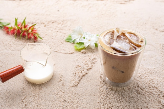 Double verre latte sur fond de plage de sable.