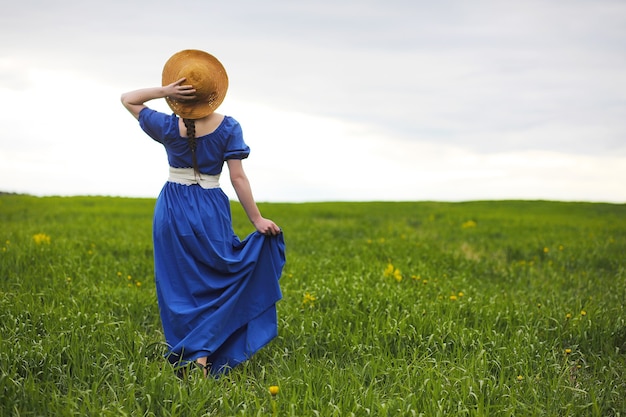 Une douce fille à la campagne lors d'une promenade le soir ensoleillé