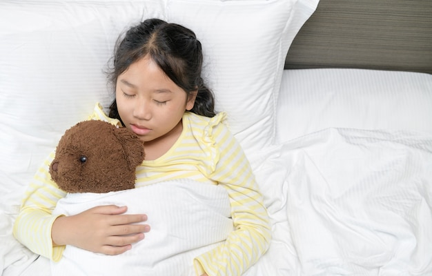 Douce Petite Fille Dort Avec Un Ours En Peluche Dans Son Lit à La Maison, Doux Rêve Et Repos Concept