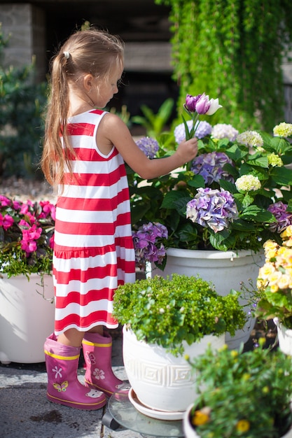 Douce petite fille tenant un bouquet de tulipes dans la cour