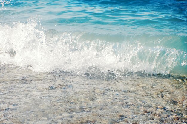 Douce vague d'océan bleu sur fond de plage de sable