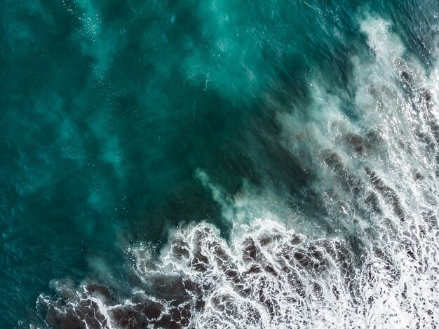 Douce vague de l'océan bleu sur la plage de sable. Contexte.