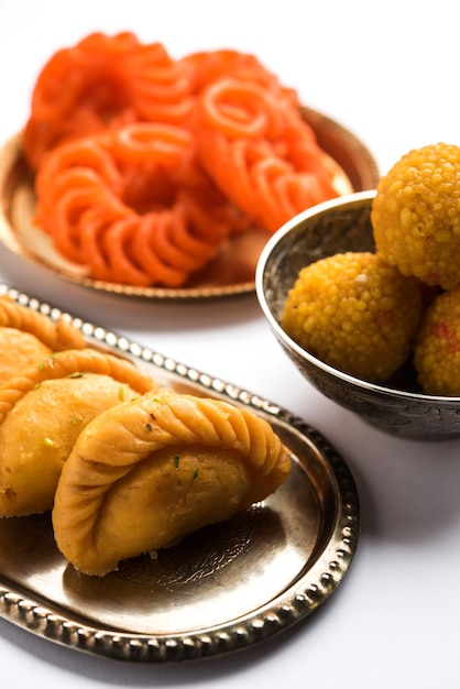 Douceur indienne Jalebi ou Imarti, Laddu et Gujiya servis ensemble sur fond blanc ou avec des cadeaux. Mise au point sélective