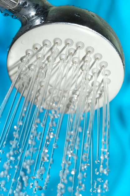 Douche avec gouttes d'eau sur fond bleu.