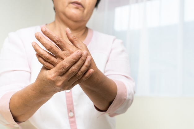 Douleur au poignet de la main de la vieille femme, problème de santé du concept senior