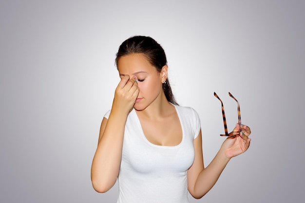 Douleur aux yeux. Belle femme malheureuse fatiguée souffrant de fortes douleurs oculaires. Concept médical