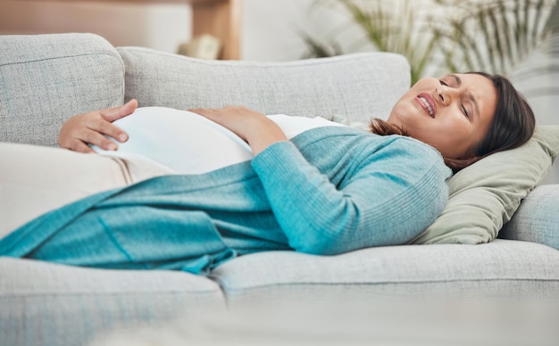 Douleur enceinte et femme en travail avec douleur à l'estomac et accouchement à la maison familiale nouvelle maman et urgence de grossesse Santé soins prénataux et respiration médicale et mal à l'abdomen avec une femme enceinte