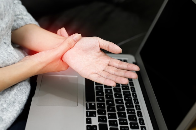 Douleur à la main femmes Douleur musculaire tout en travaillant à l'ordinateur