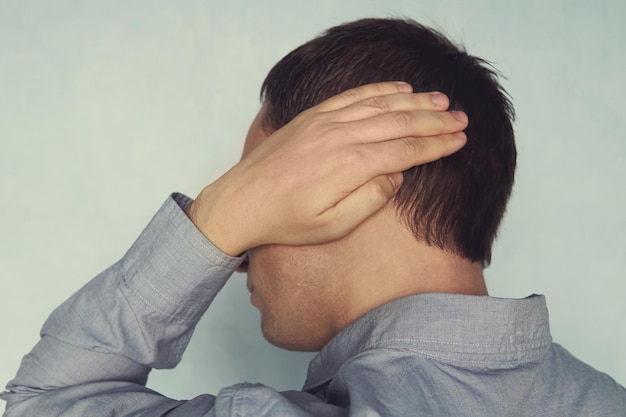 Douleur à l'oreille chez un homme qu'un jeune patient tient à une otite d'oreille malade