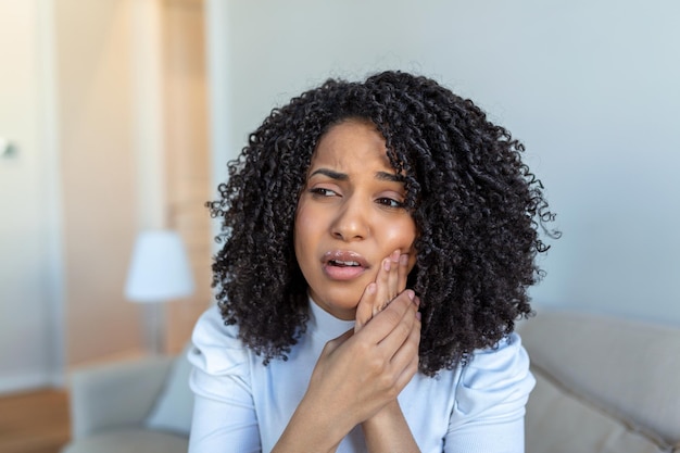 Photo douleurs dentaires et dentisterie belle jeune femme souffrant d'une terrible douleur dentaire forte toucher la joue avec la main femme se sentant douloureuse douleur dentaire soin dentaire et santé concept haute résolution