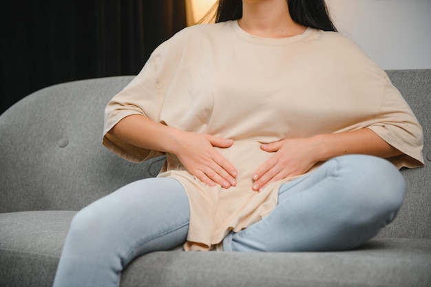 Douleurs menstruelles femme souffrant de maux d'estomac souffrant de pms à la maison endométriose cystite et autres maladies du système urinaire