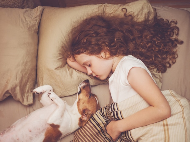 Doux bébé et son petit chien dort la nuit.