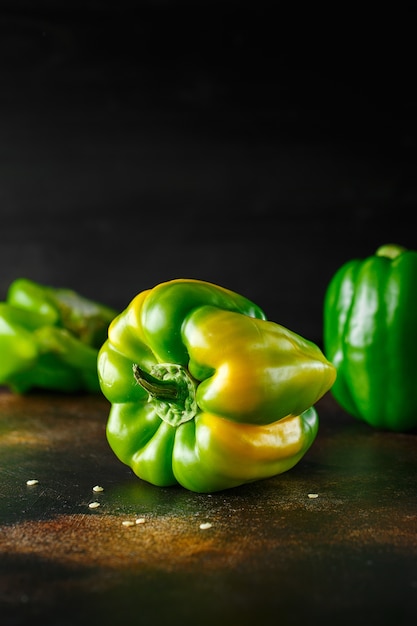 Doux gros poivron vert sur table sombre