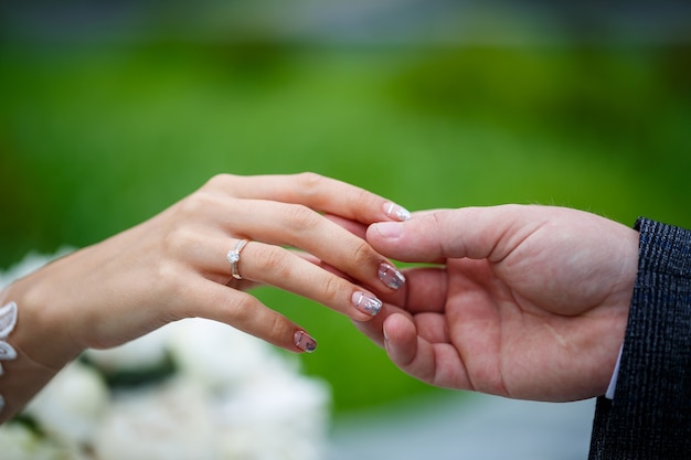 Doux mains féminines de la mariée avec une bague de mariage en or sur l'annulaire