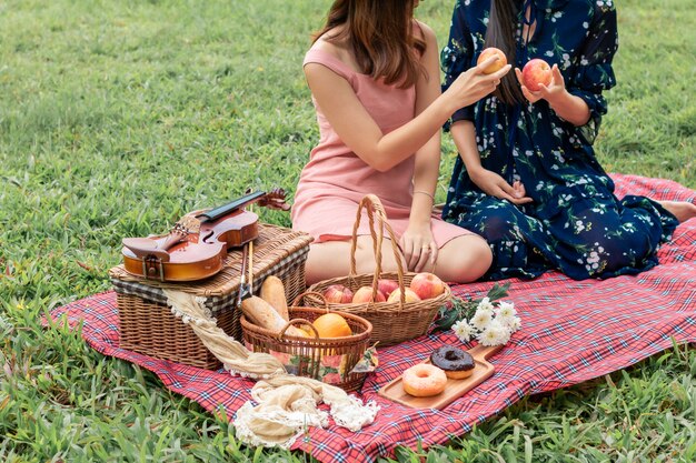 Doux moment d'amour.Portrait de couple homosexuel asiatique jouant avec le violon et pique-nique dans le parc.Concept LGBT leasbian.