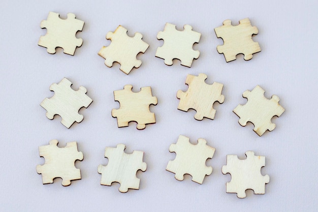 Douze puzzles en bois disposés sur une vue de dessus de fond beige