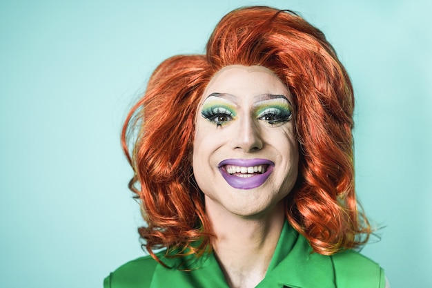 Drag queen souriant à la caméra avec un fond turquoise - Concept Lgbtq - Focus on face