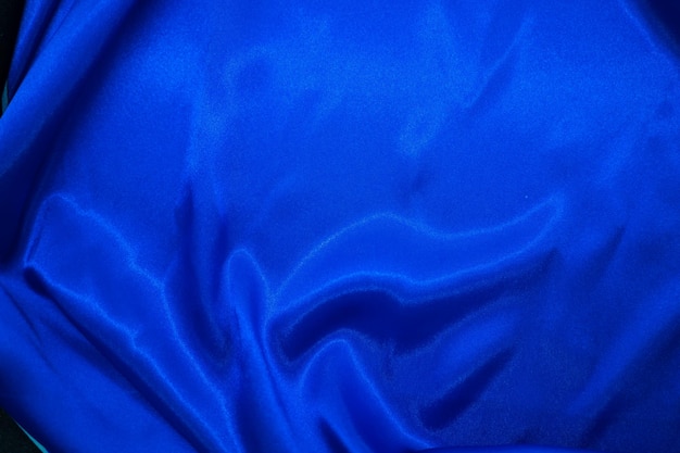 Drapé textile en tissu soyeux en satin bleu marine abstrait avec fond de plis ondulés de pli