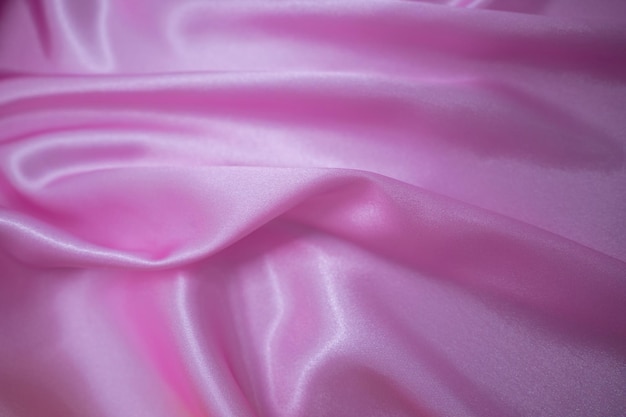 Drapé textile en tissu soyeux en satin rose abstrait avec fond de plis ondulés de pli