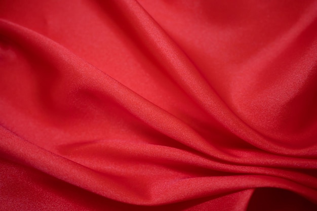 Drapé textile en tissu soyeux en satin rouge abstrait avec fond de plis ondulés de pli