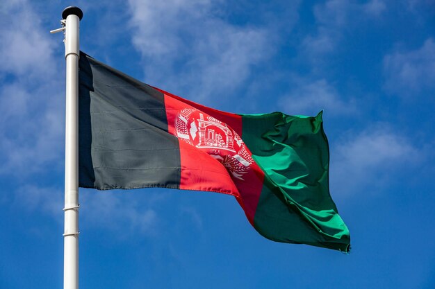 Drapeau de l'Afghanistan agitant contre un ciel bleu clair