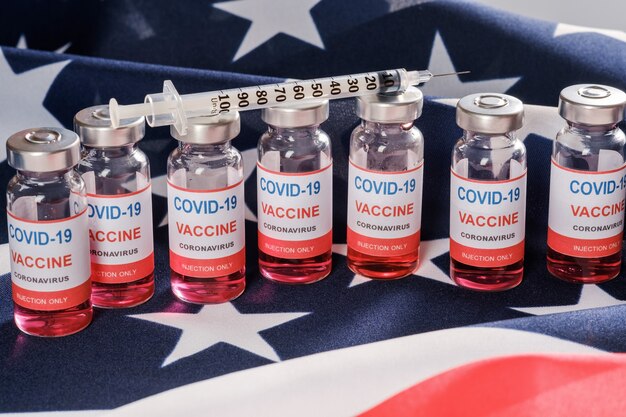 Drapeau américain, flacons de vaccin contre le coronavirus et seringue.