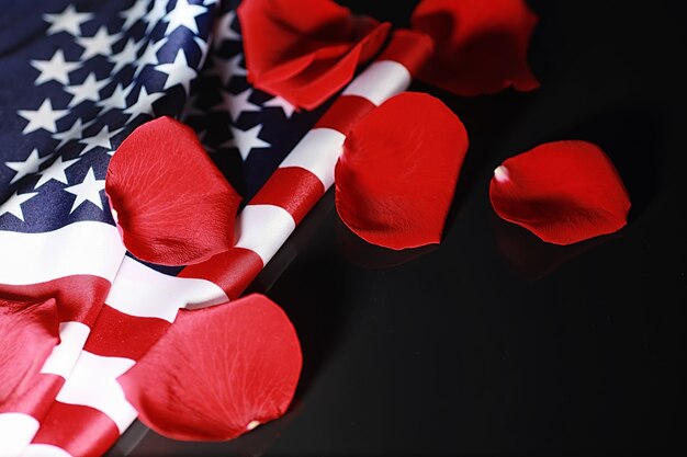 Drapeau américain et fleur rose sur la table. Symbole des États-Unis d'Amérique et pétales rouges. Patriotisme et mémoire.