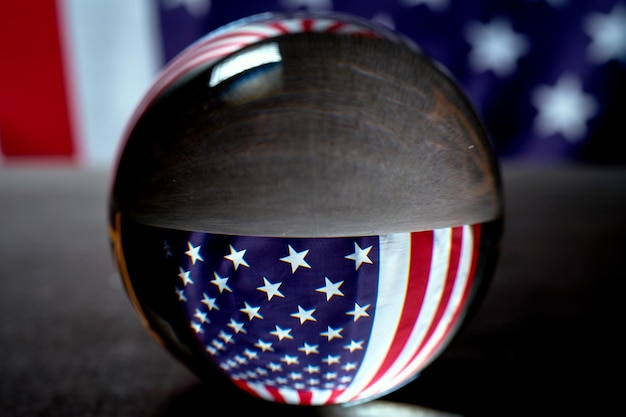 Photo un drapeau américain sur un fond noir visible à travers une boule brillante en verre