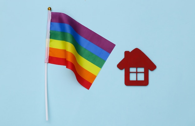 Drapeau arc-en-ciel LGBT et maison sur fond bleu. Tolérance, liberté