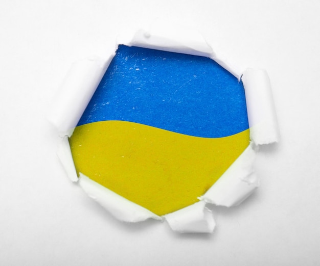 Photo drapeau bleu et jaune ukrainien dans le trou rond en papier