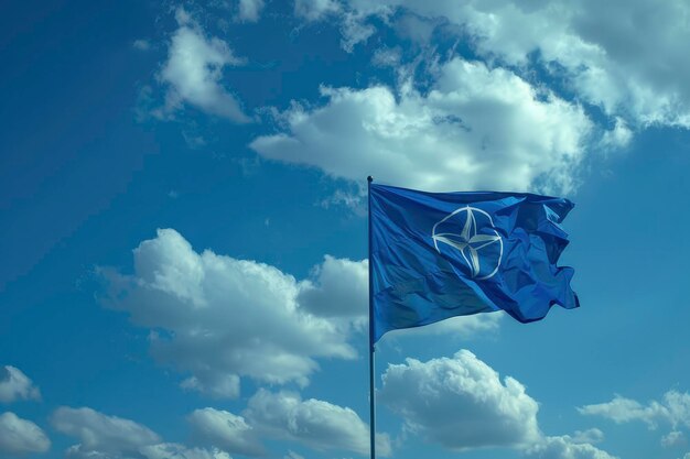 Photo drapeau bleu avec le symbole de l'otan volant dans le ciel