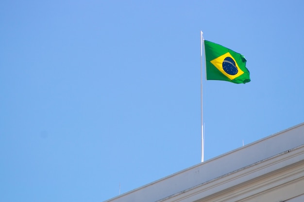 Drapeau brésilien à l'extérieur au sommet d'un immeuble sur la plage de Copacabana