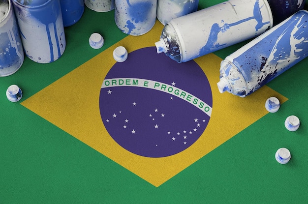 Drapeau brésilien et quelques aérosols utilisés pour la peinture de graffitis Concept de culture d'art de rue
