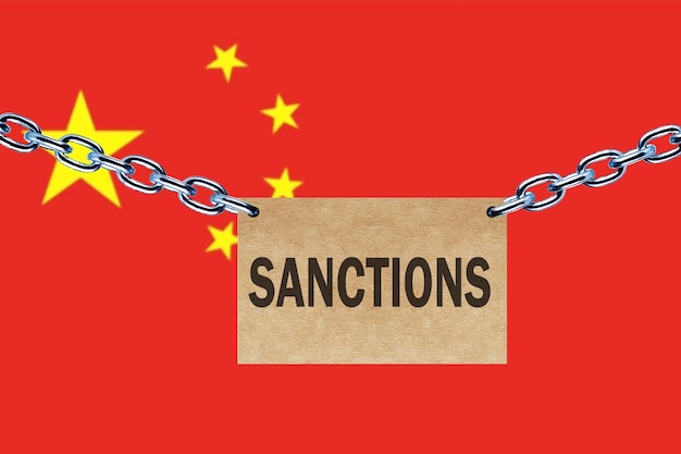 Drapeau chinois enchaîné et affiche avec message sanctions économiques pour la Chine