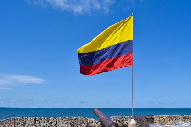 Drapeau de la Colombie flottant et canon sur le mur de la ville fortifiée dans le centre historique de Carthagène.