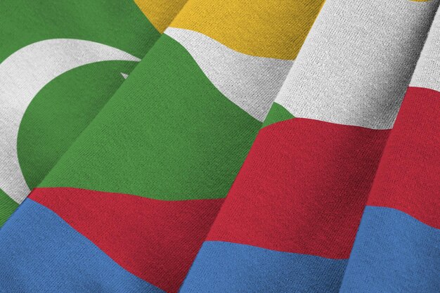 Photo drapeau des comores avec de grands plis agitant de près sous la lumière du studio à l'intérieur les symboles officiels