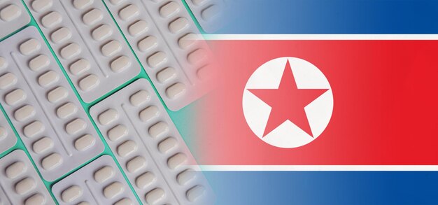 Drapeau de la Corée du Nord avec comprimés Développements pharmacologiques dans le domaine des médicaments pharmaceutiques antibiotiques analgésiques et épidémies Augmentation de la consommation de médicaments