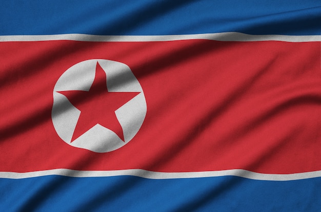 Le drapeau de la Corée du Nord est représenté sur un tissu de sport avec de nombreux plis.