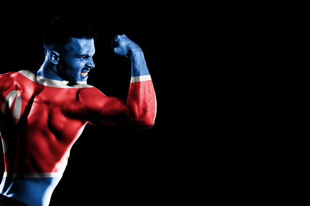 Photo drapeau de la corée du nord sur fond noir beau jeune homme musclé